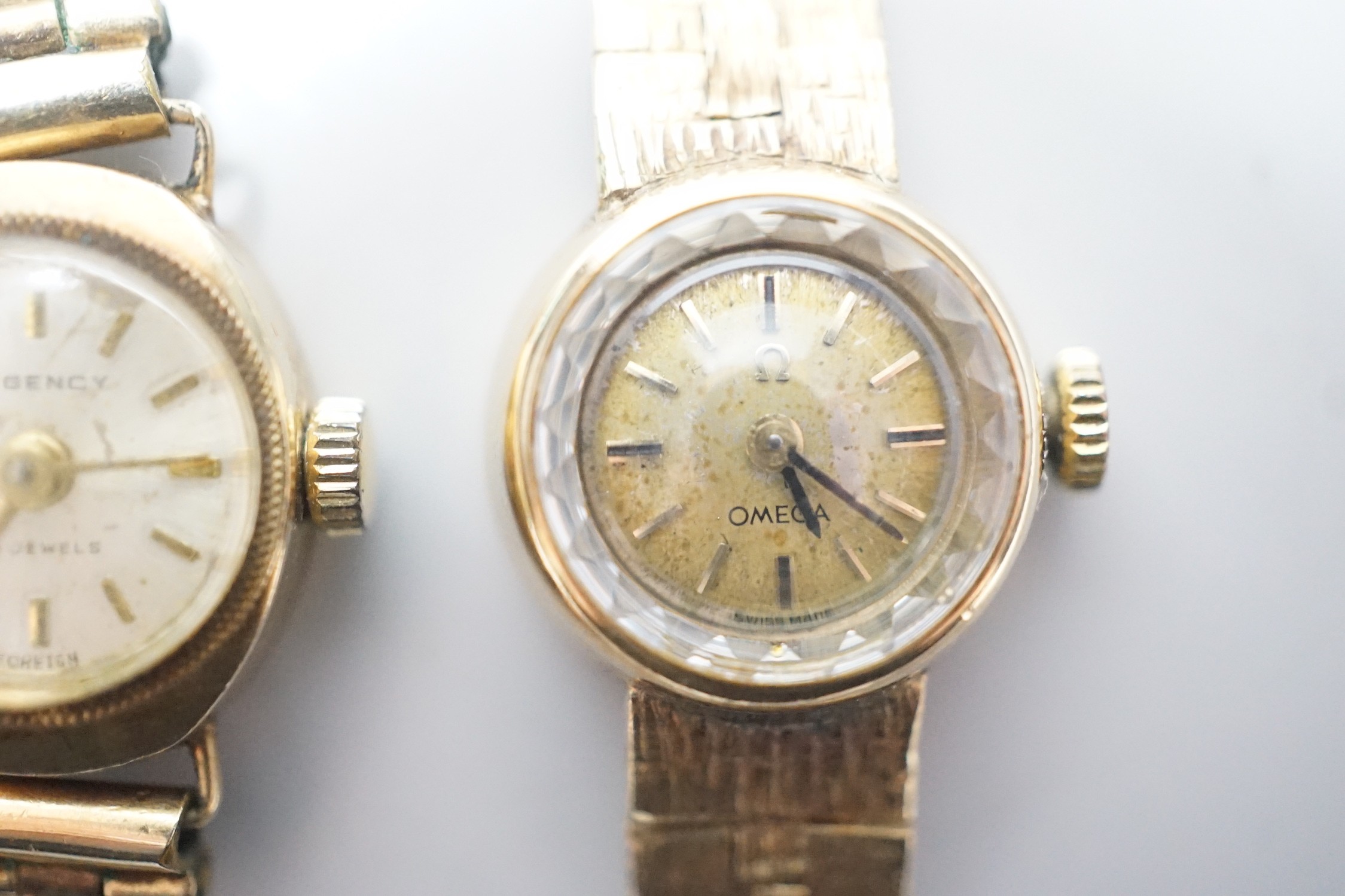 A lady's 9ct gold Omega manual wind wrist watch, on associated 9ct gold bracelet, overall 15.8cm, gross weight 17.8 grams and one other lady's 9ct gold watch on a gold plated bracelet.